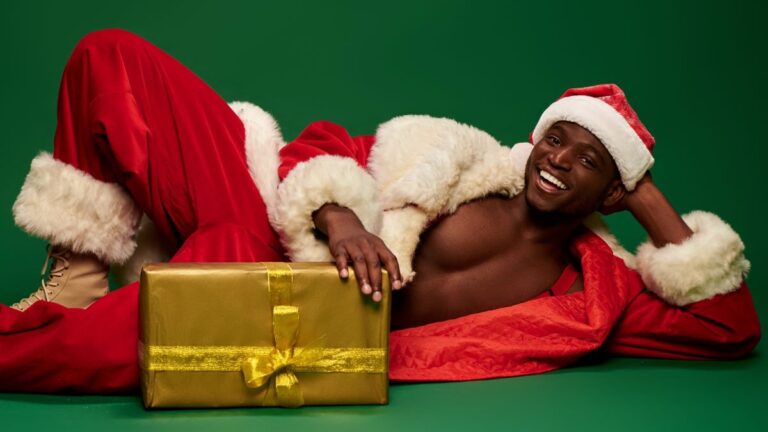 Black santa on green background lying down with gift