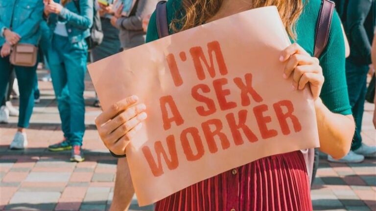 I am a sex worker sign held up by a woman in a dress