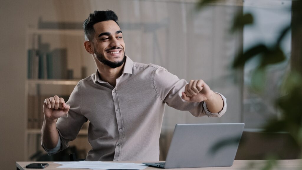 Happy arabic man using laptop do to work.