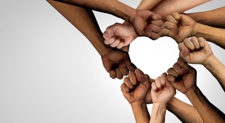 Hands and arms with different skin tones pressed together to form the shape of a heart