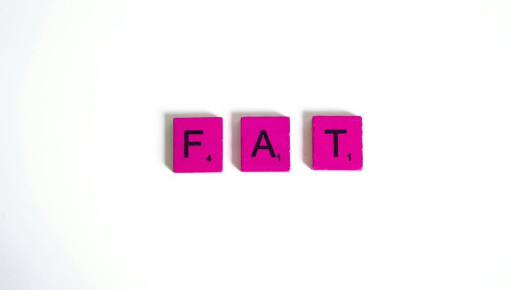 Hot pink scrabble letters spelling F A T on a white background