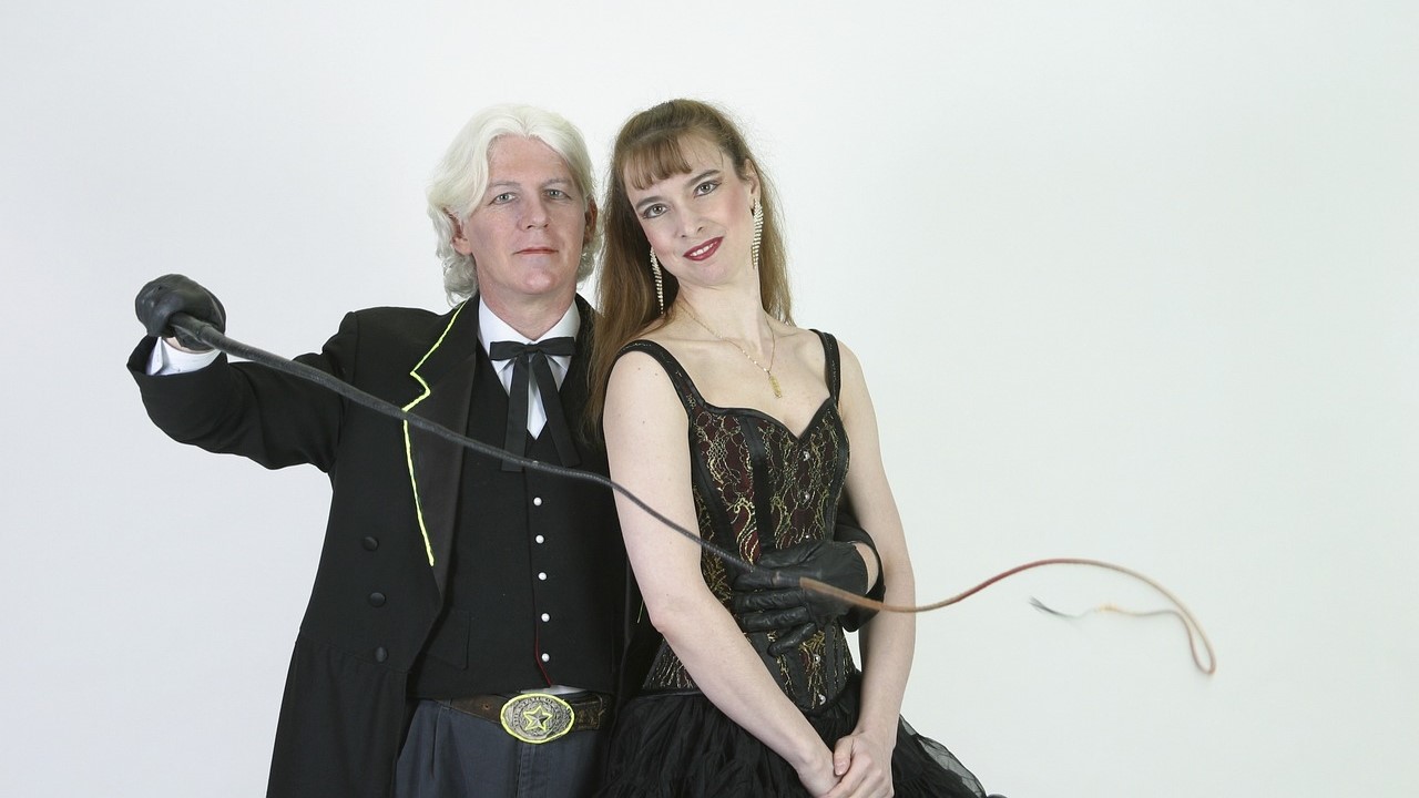 bdsm heterosexual couple wearing black, man holding whip