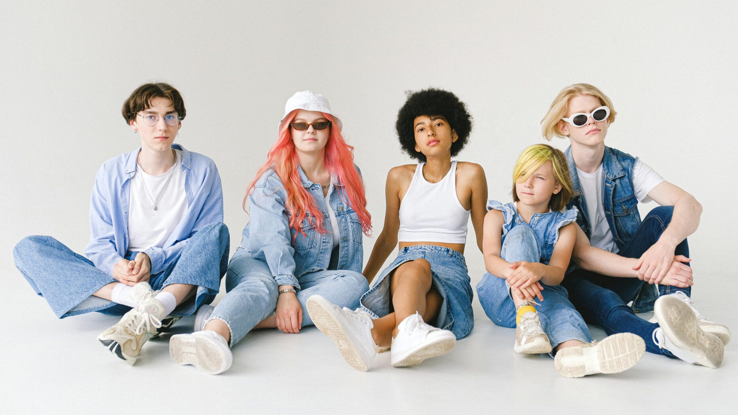 a group of diverse teens set against a white backround. All seated.