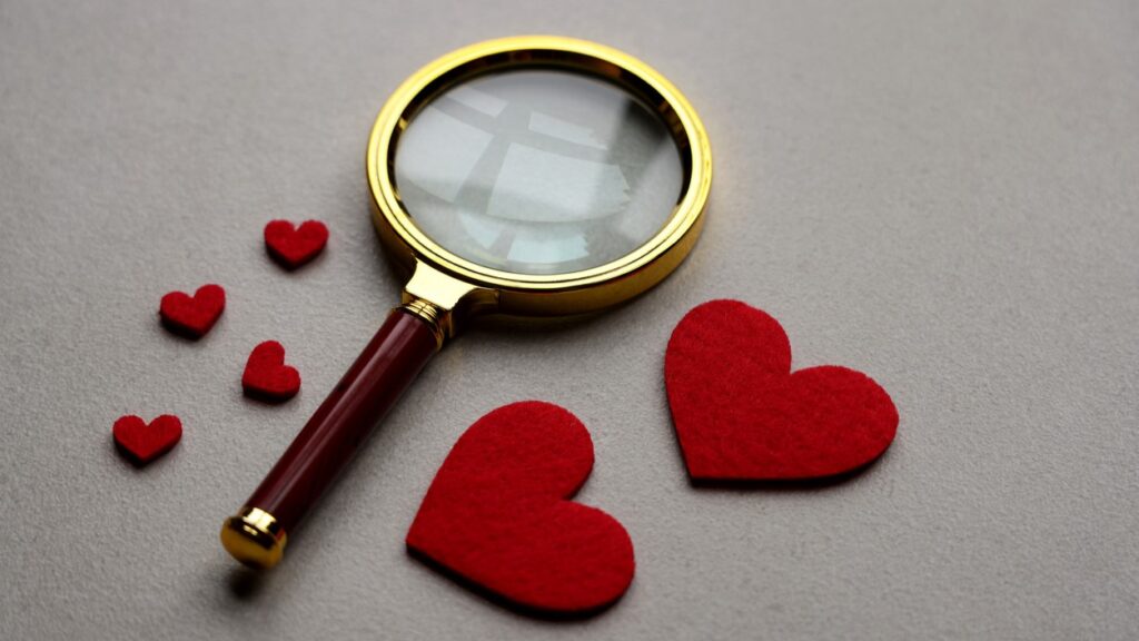 a magnifying glass next to hearts