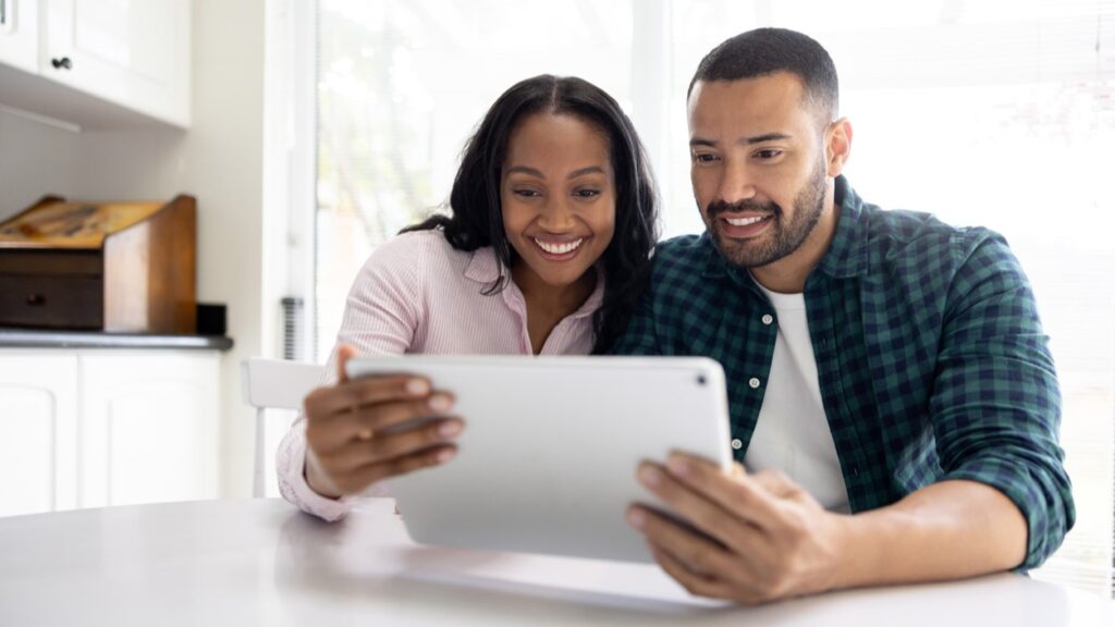 Black hetero couple in kitchen with tablet