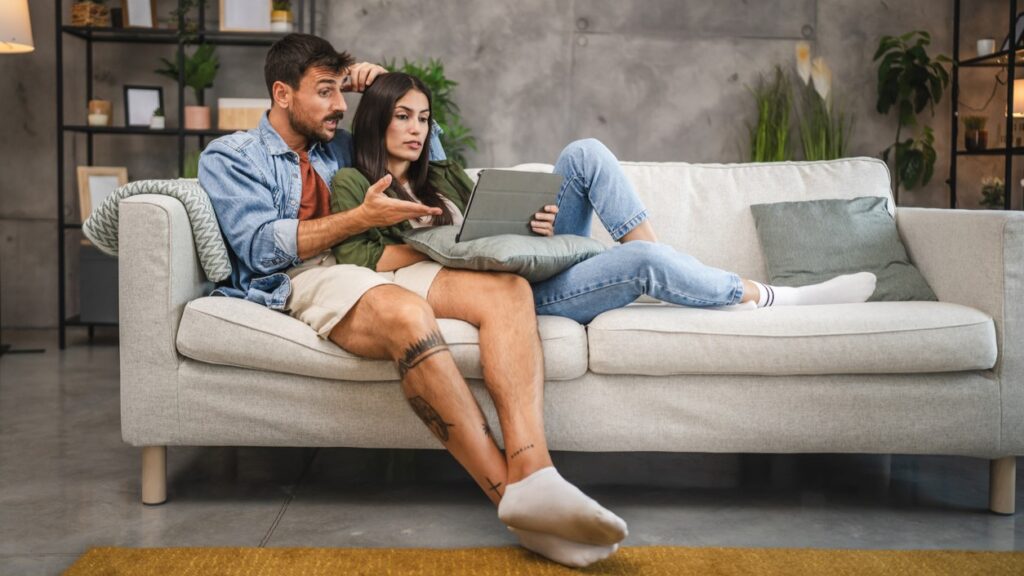 White hetero couple on couch with tablet