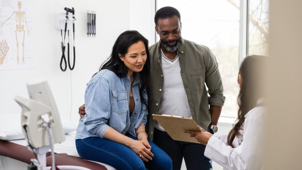 multi ethnic couple talking to a doctor about infertility